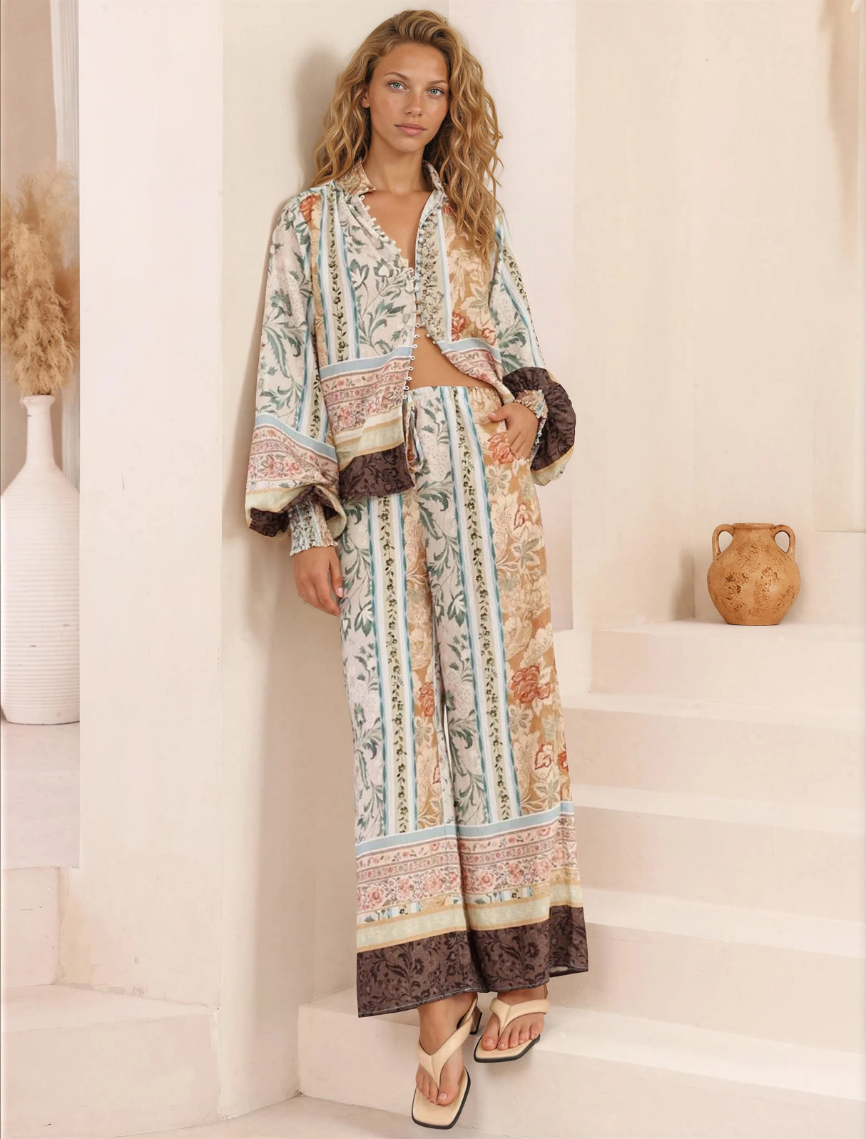 Woman wearing a long, patterned dress standing on a staircase.