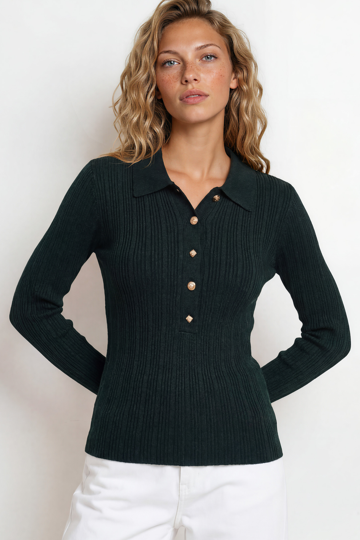 Woman wearing a dark green ribbed sweater with buttons on a white background