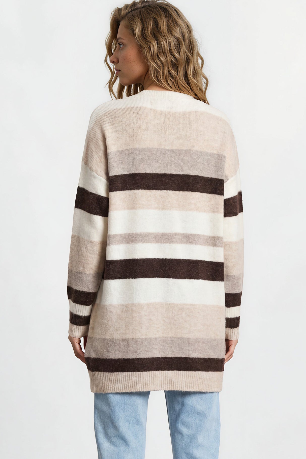 Person wearing a striped sweater and light blue jeans against a white background