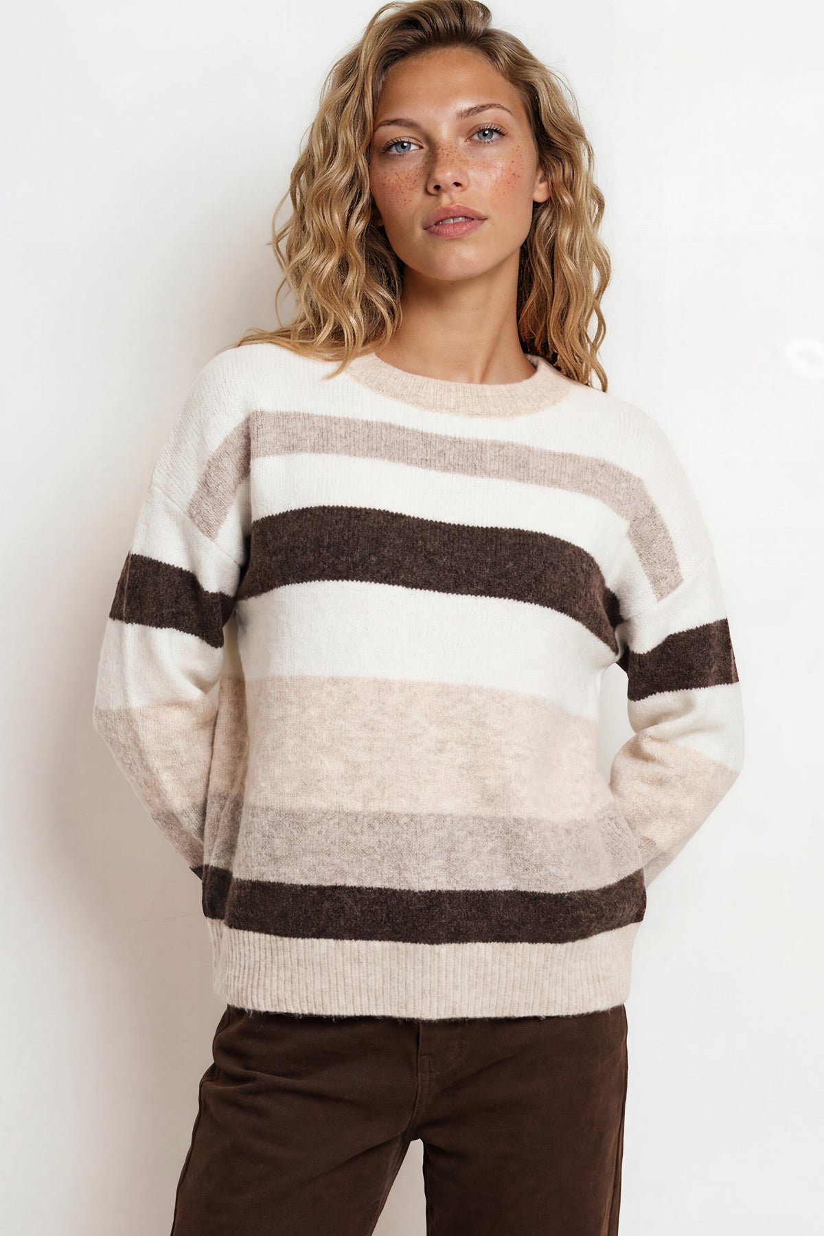 Woman wearing a striped sweater with a plain background