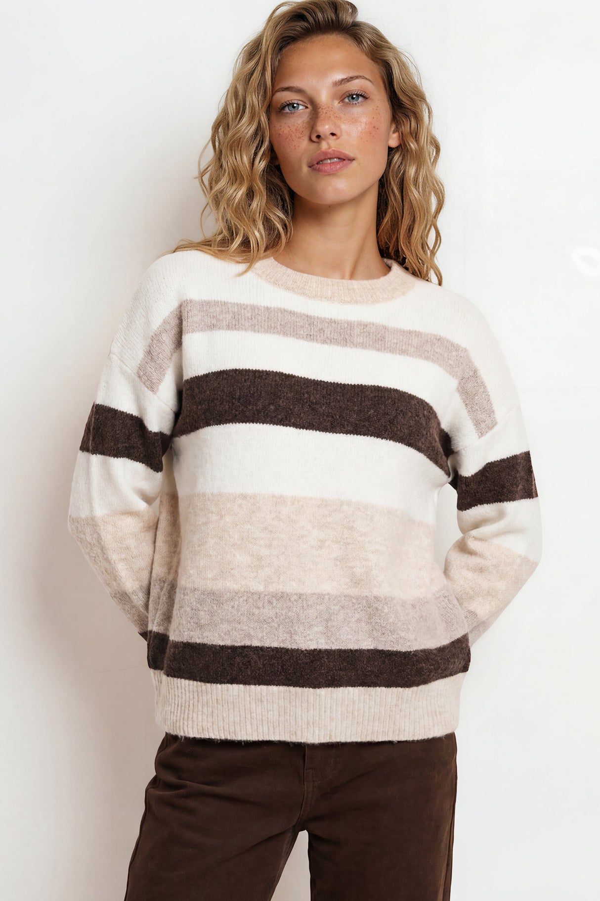 Woman wearing a striped sweater with a plain background