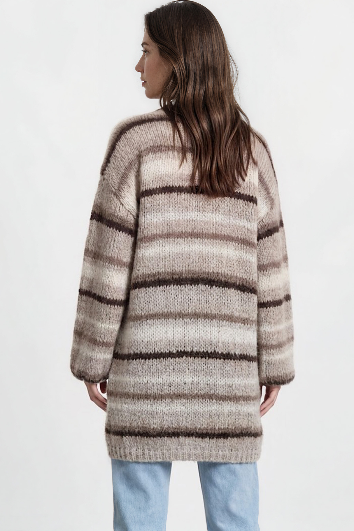 Woman wearing a striped sweater and light blue jeans on a white background