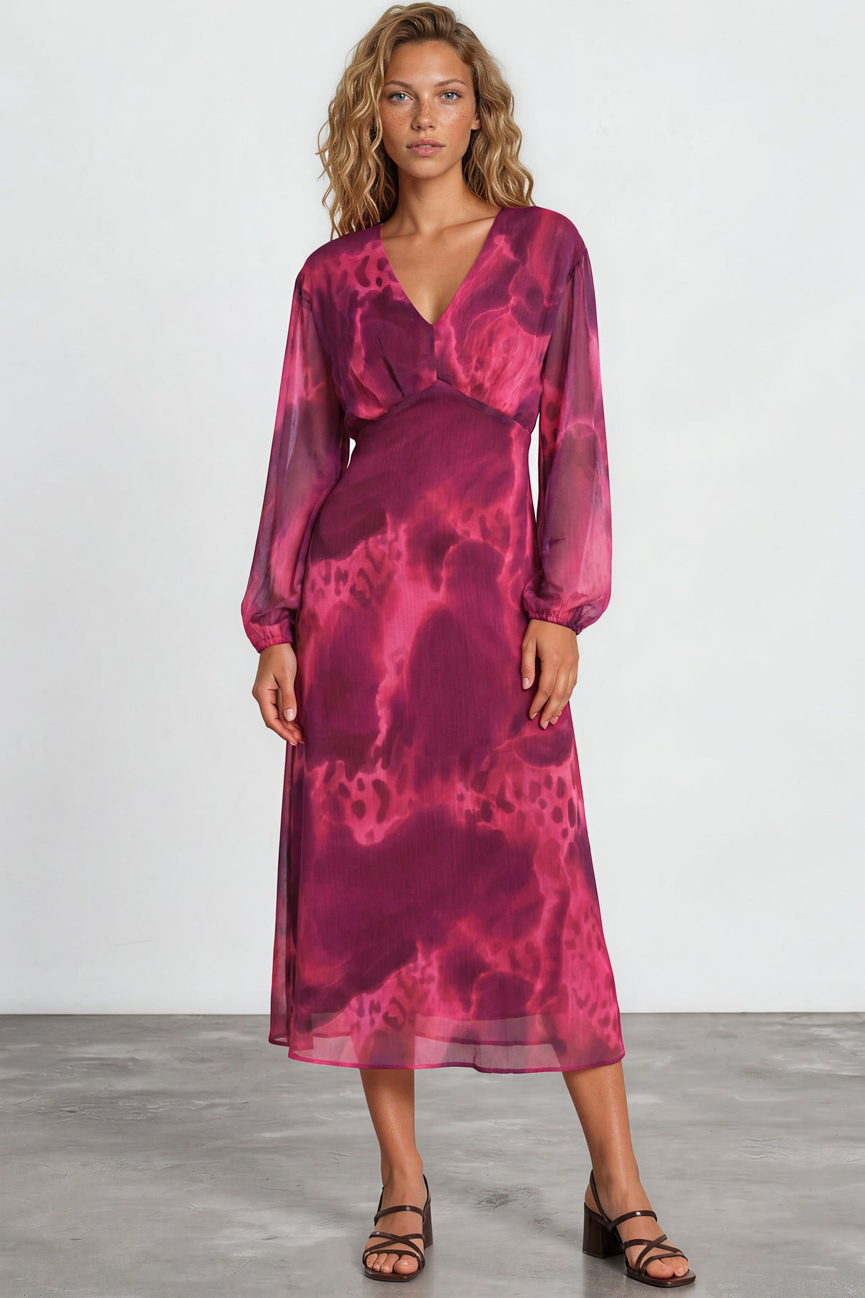 Woman wearing a pink tie-dye dress against a white background