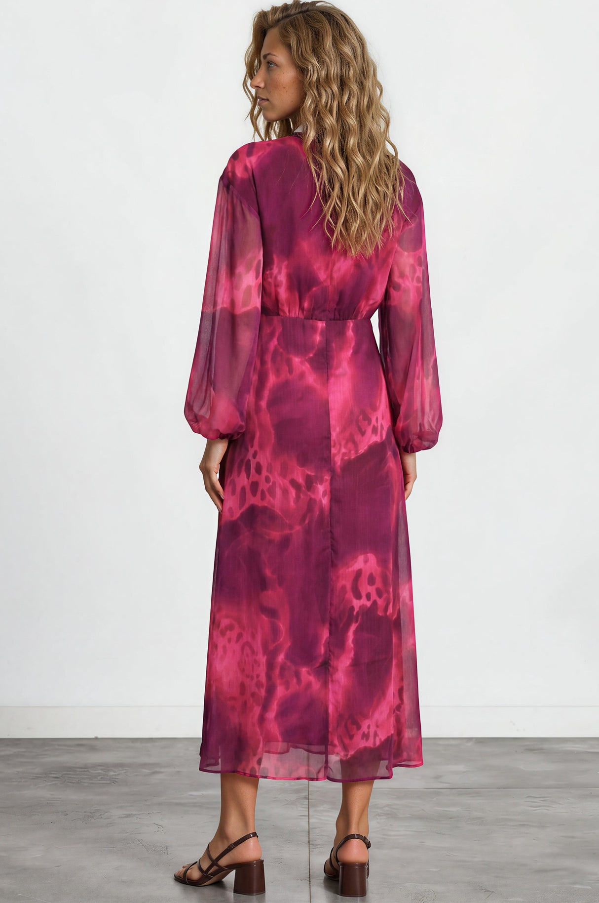 Woman wearing a pink tie-dye dress on a white background