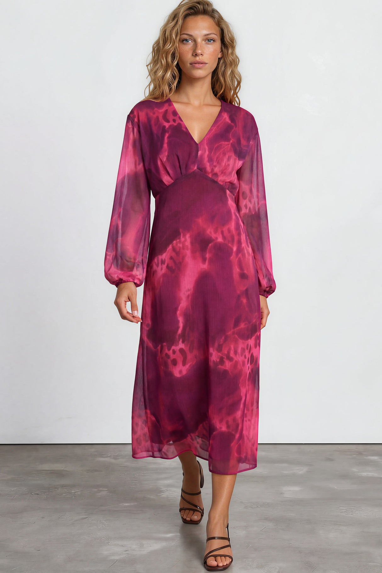 Woman wearing a pink tie-dye dress on a plain background