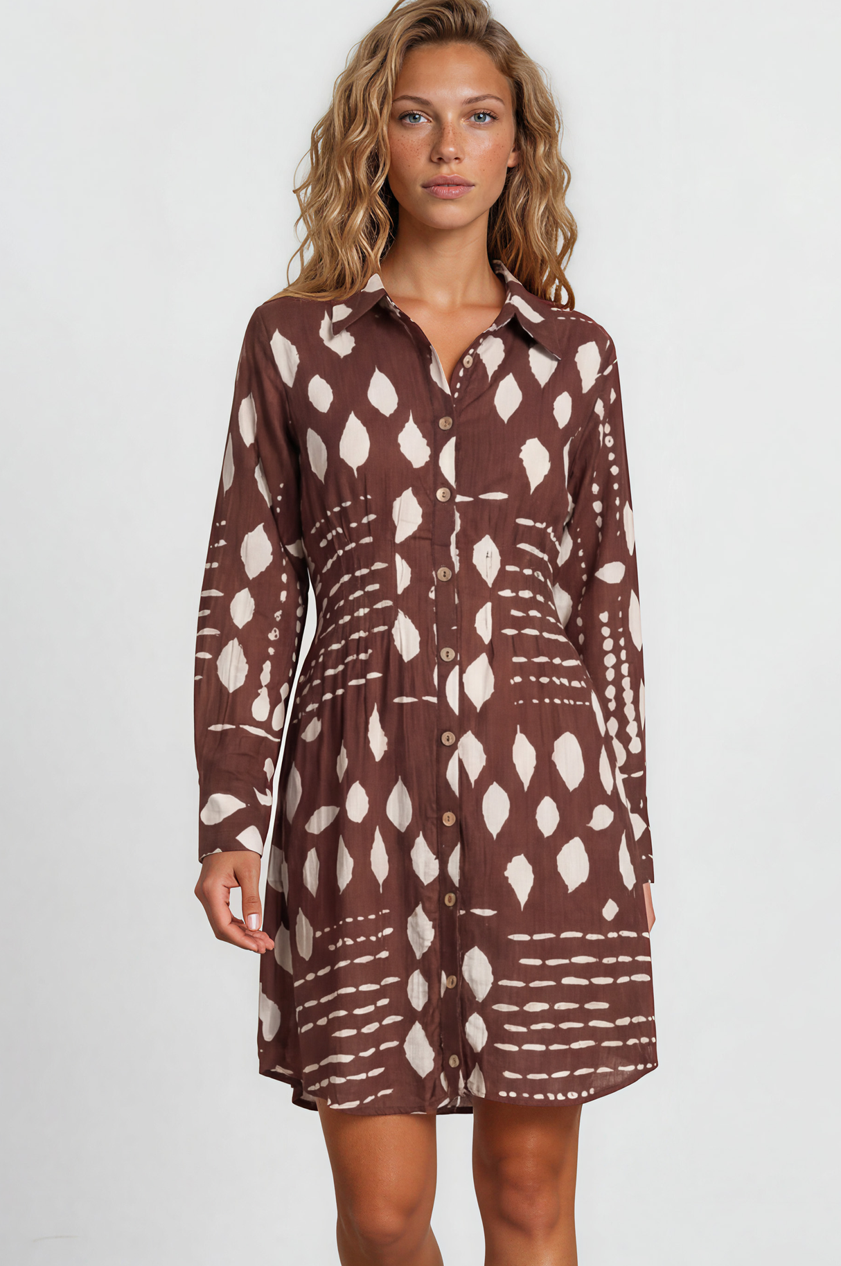 Woman wearing a brown patterned dress on a plain background