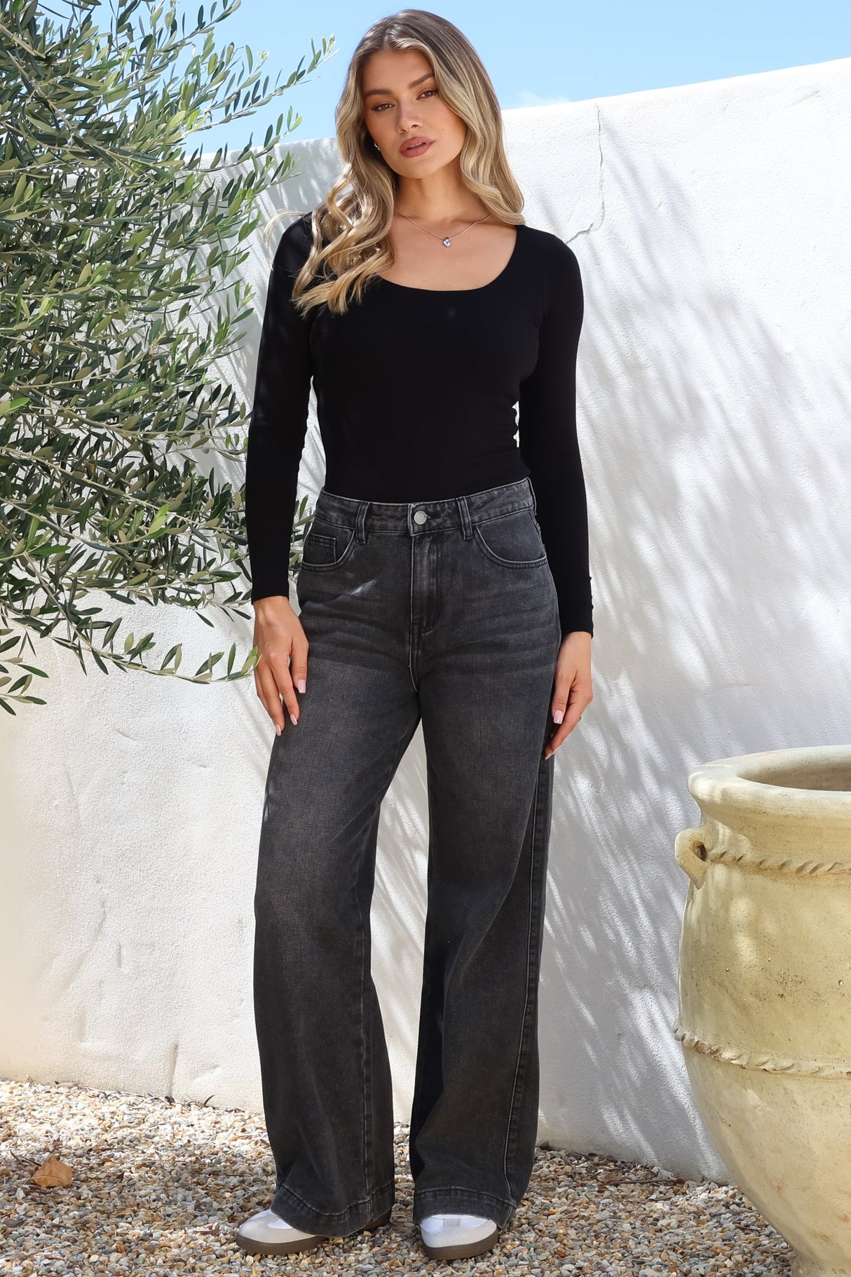 Model wearing Kash Jeans in Black Acid Wash from Salty Crush