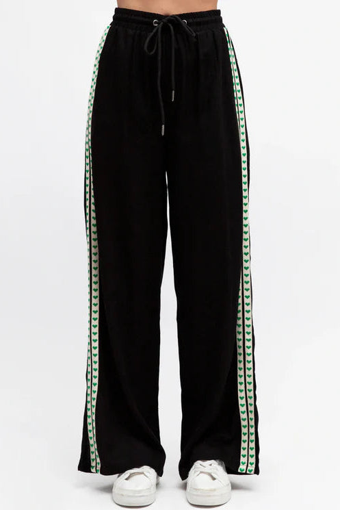 Black pants with green stripes on a white background