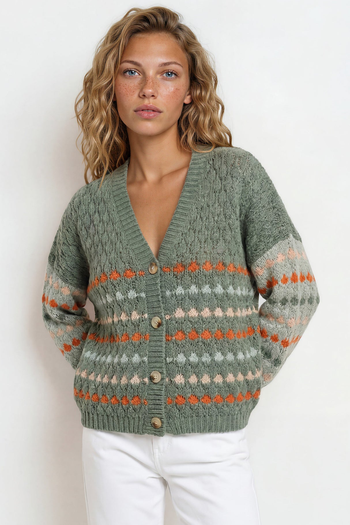 Woman wearing a green patterned cardigan against a white background