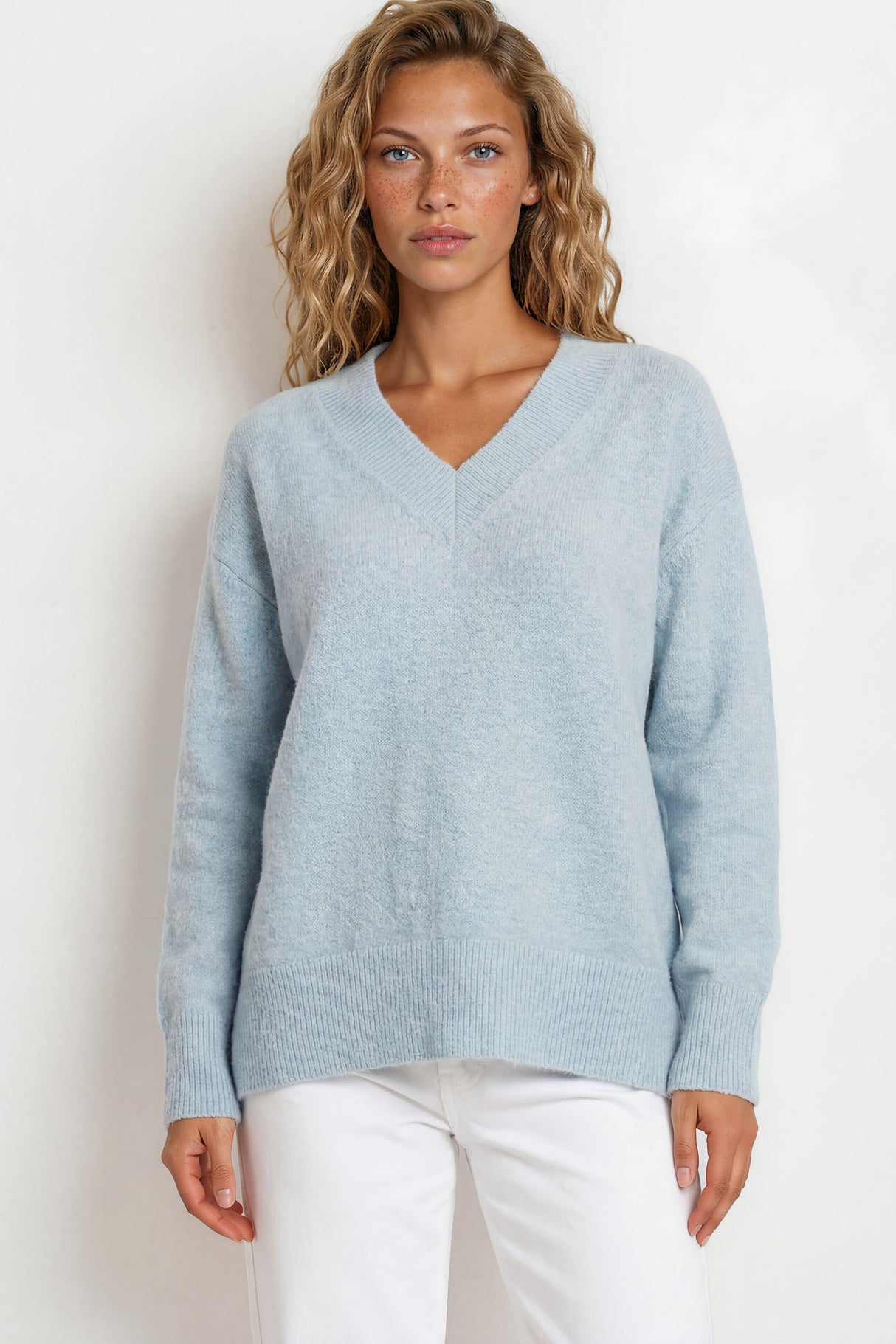 Woman wearing a light blue sweater against a white background