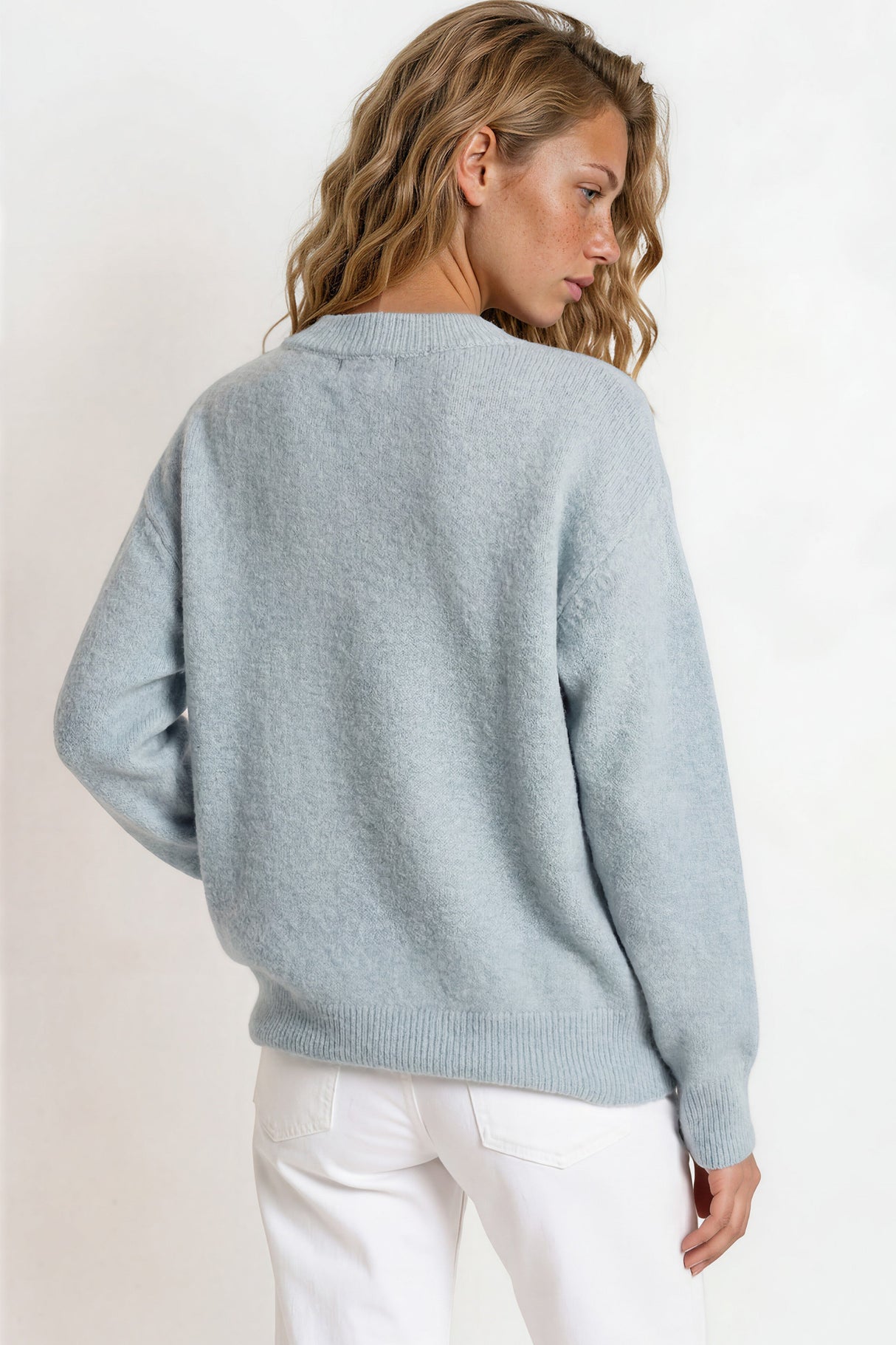 Woman wearing a light blue sweater against a white background