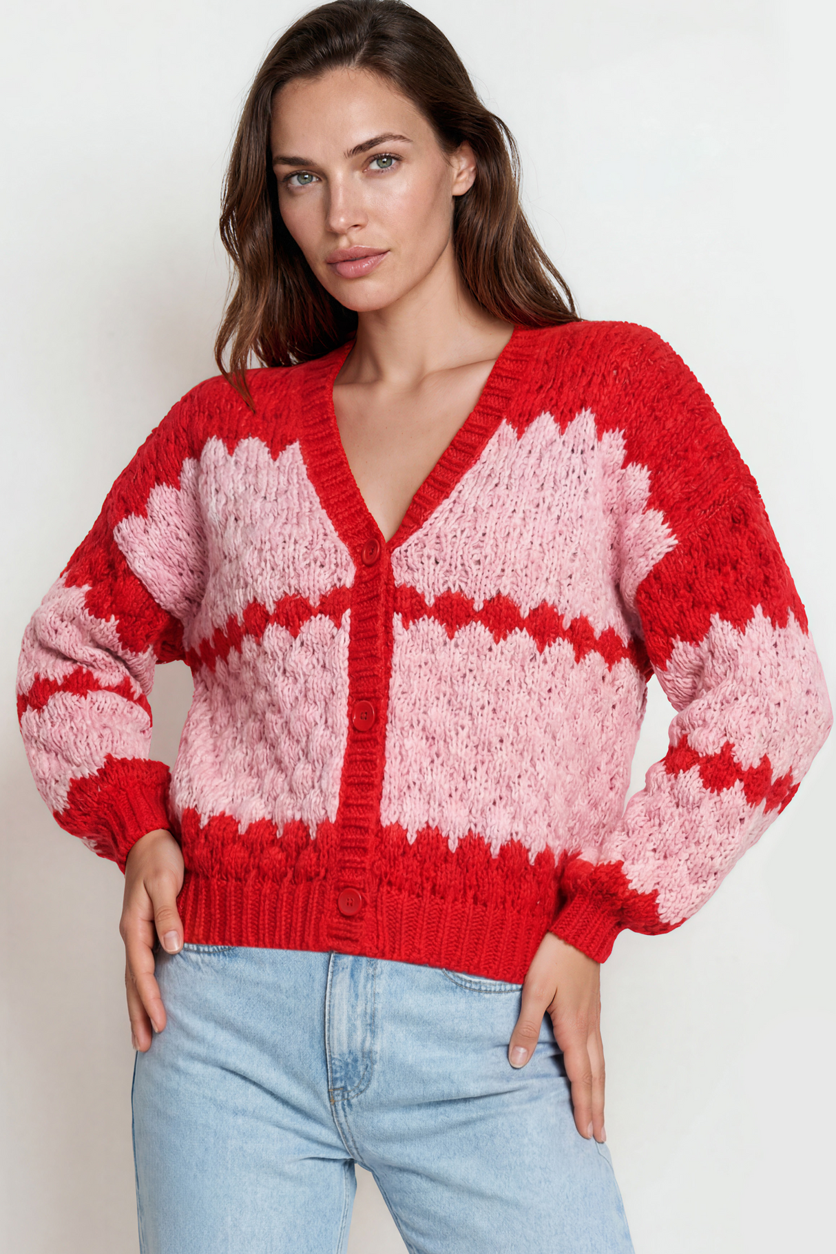 Woman wearing a red and pink patterned sweater against a white background
