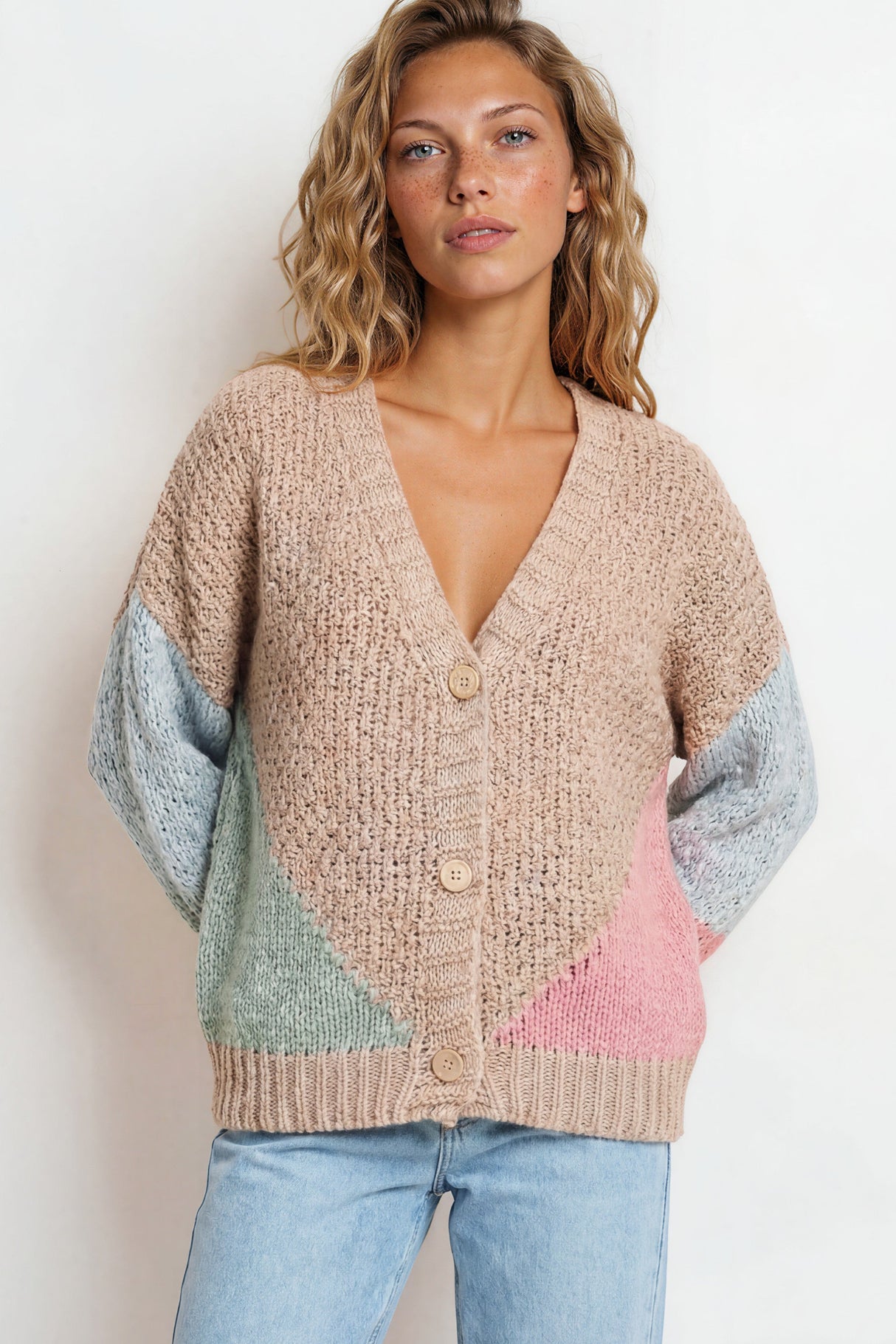Woman wearing a colorful cardigan with a plain background