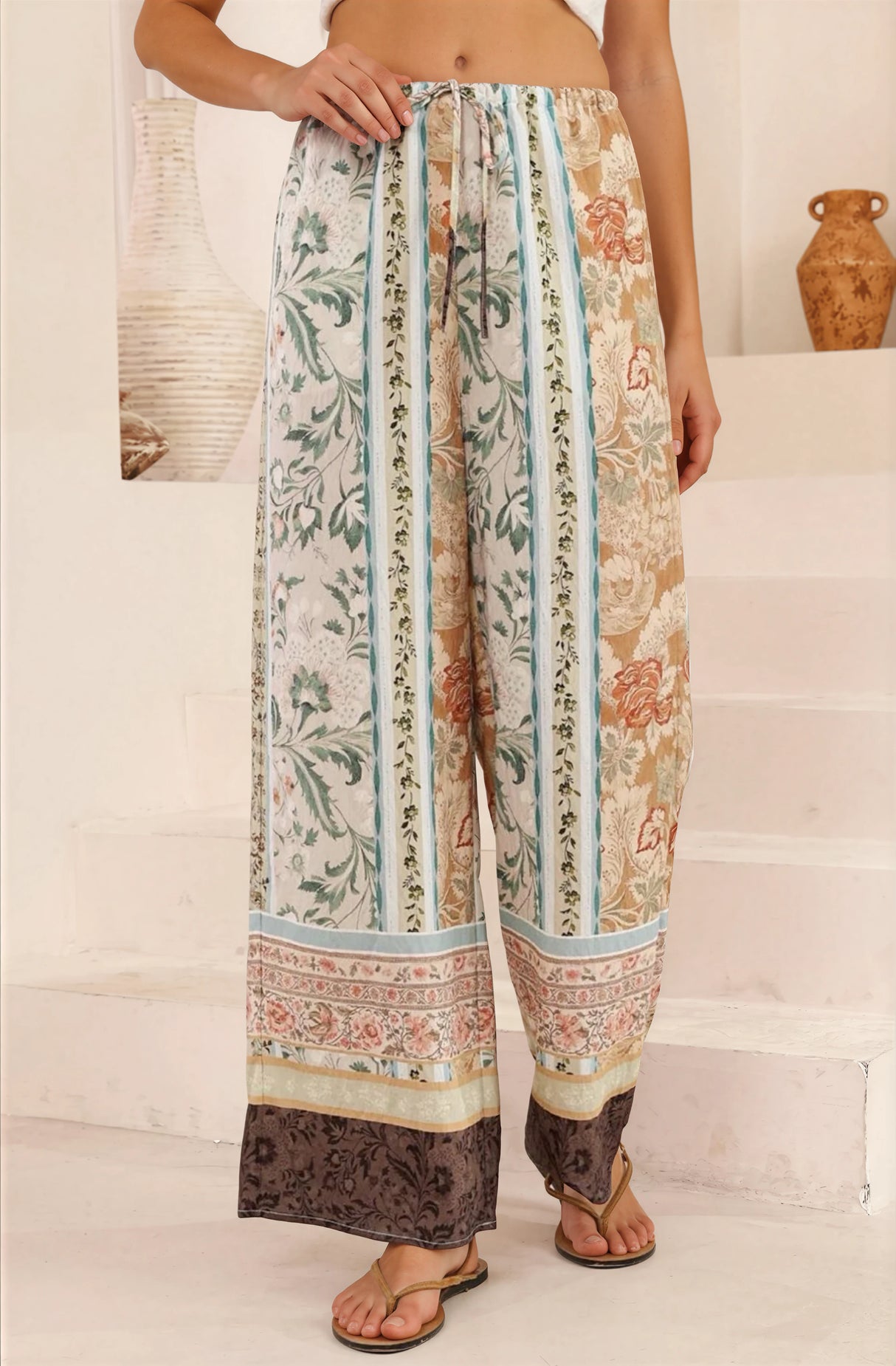 Person wearing floral-patterned pants on a white staircase
