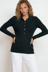 Woman wearing a black ribbed sweater with button details against a white background