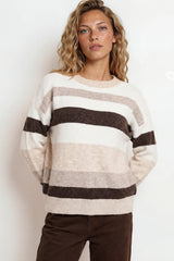 Woman wearing a striped sweater with a plain background