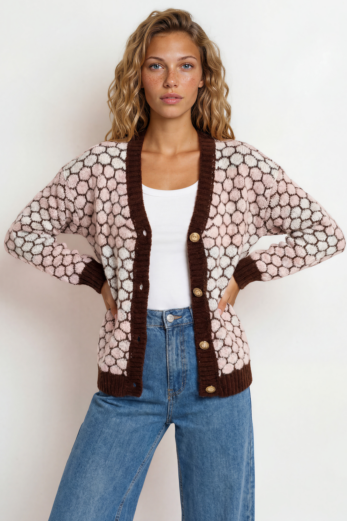 Woman wearing a patterned cardigan with brown trim on a white background
