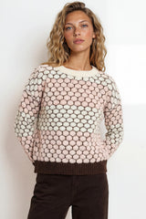 Woman wearing a patterned sweater against a plain background