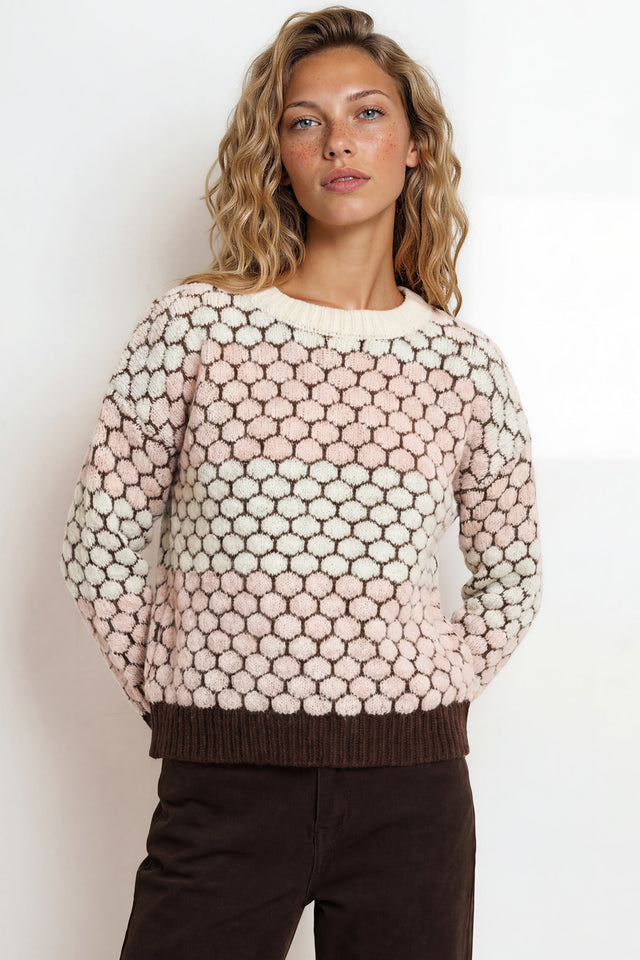 Woman wearing a patterned sweater against a plain background