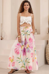 Woman wearing a white top and floral skirt in a room with decorative elements.
