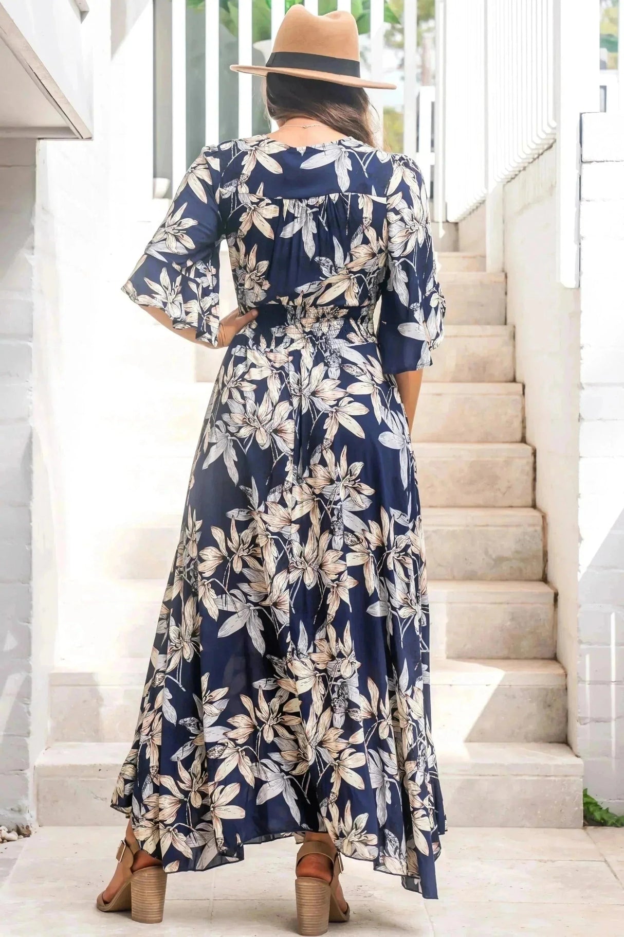 Model shows off the back side of the Frigg Maxi Dress - a floral boho dress and very popular style from Salty Crush