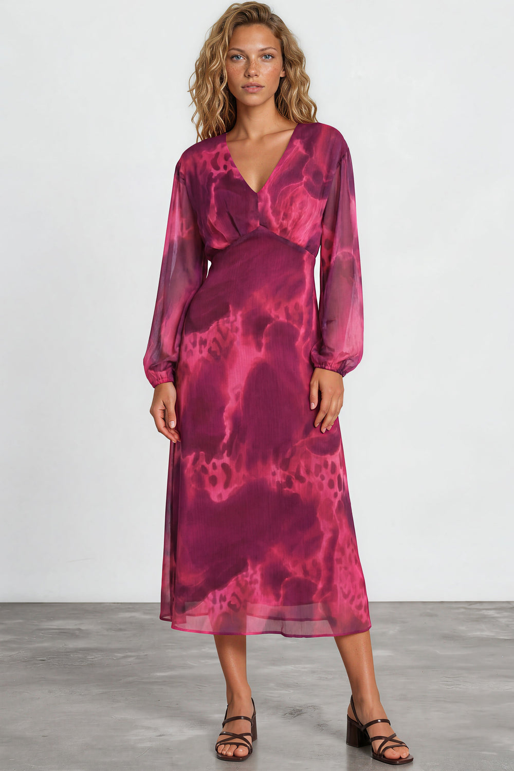 Woman wearing a pink tie-dye dress against a white background