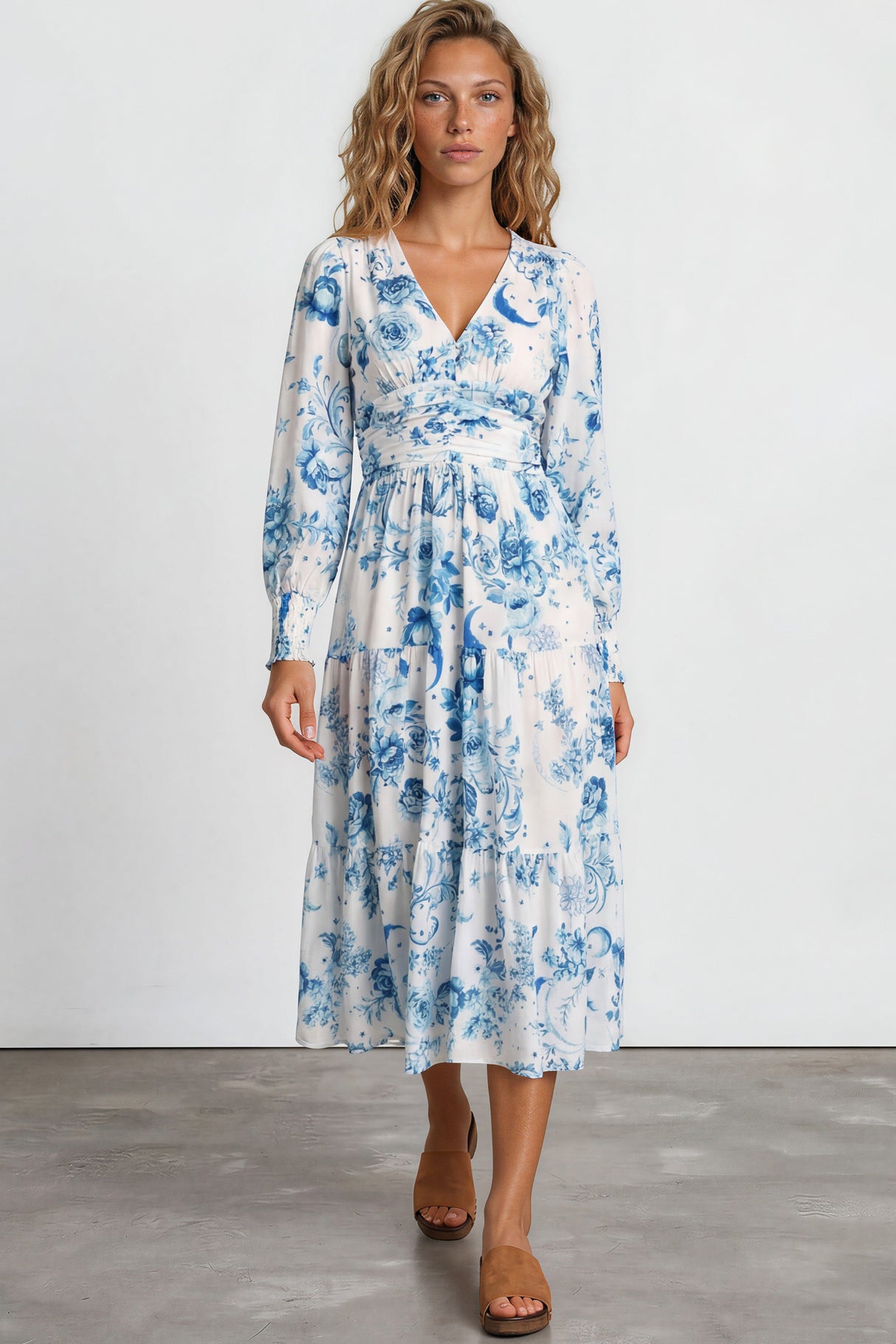 Woman wearing a blue floral dress on a plain background
