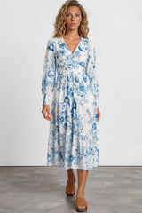 Woman wearing a blue floral dress on a plain background