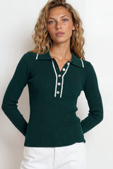Woman wearing a green long-sleeve polo shirt with white buttons against a plain background