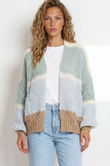 Woman wearing a patterned cardigan with a plain background