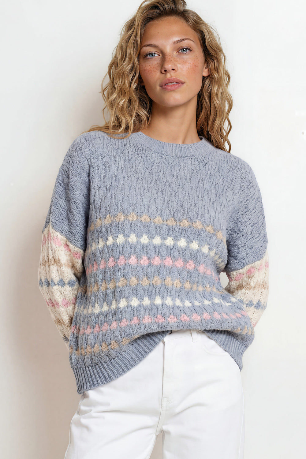 Woman wearing a patterned sweater with a plain background
