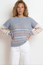 Woman wearing a patterned sweater with pastel sleeves against a white background