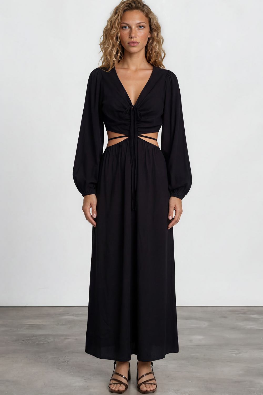 Woman wearing a black dress with cut-out design on a white background
