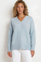 Woman wearing a light blue sweater against a white background