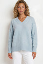 Woman wearing a light blue sweater against a white background