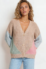 Woman wearing a colorful cardigan with a plain background