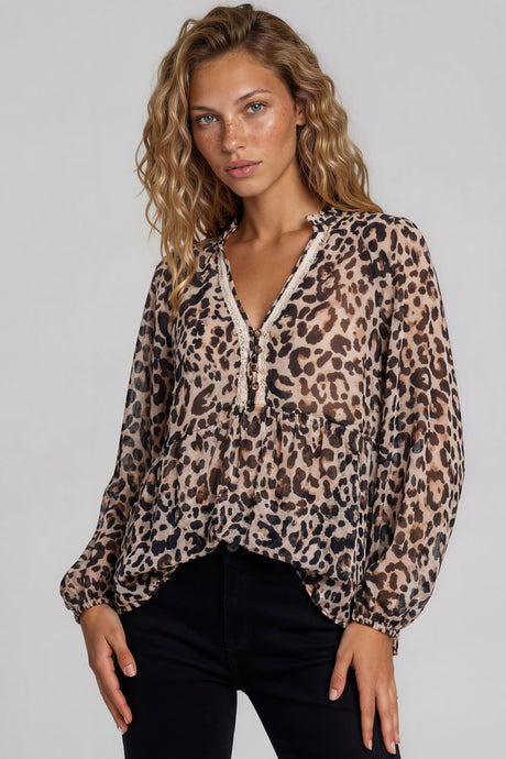 Woman wearing a leopard print blouse against a plain background