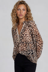 Woman wearing a leopard print blouse against a plain background