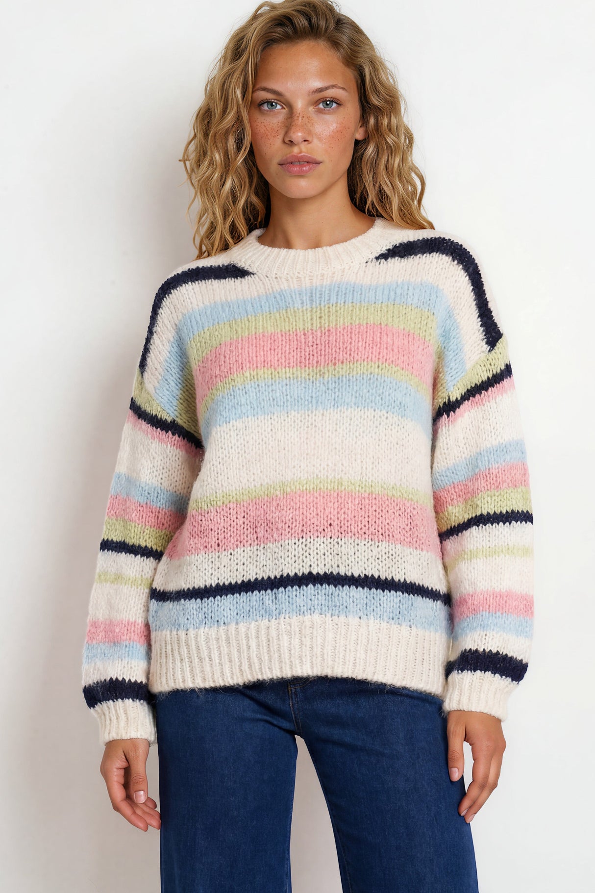 Woman wearing a colorful striped sweater against a white background