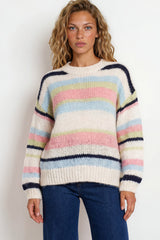 Woman wearing a colorful striped sweater against a white background