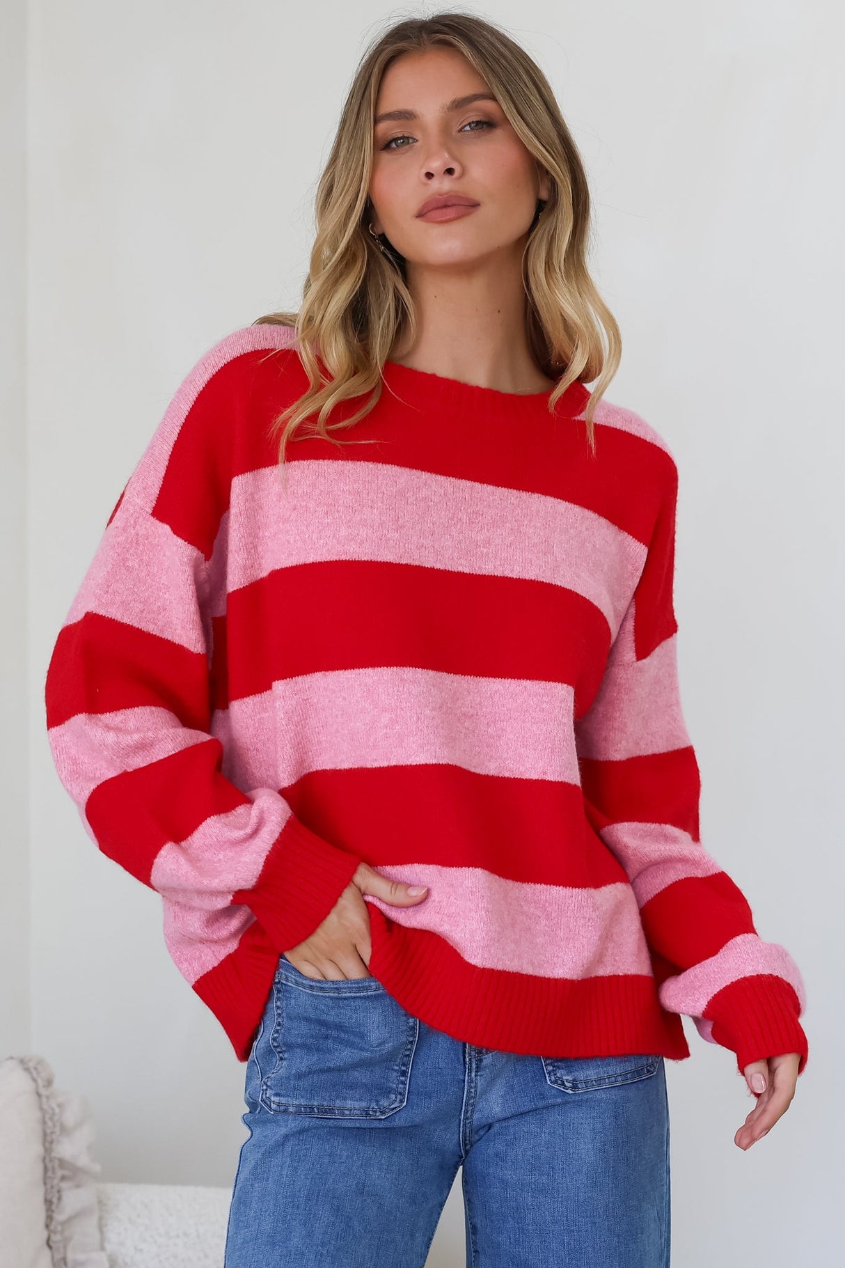 Model wearing a pink and red striped jumper called Sumner Jumper in Red from Salty Crush
