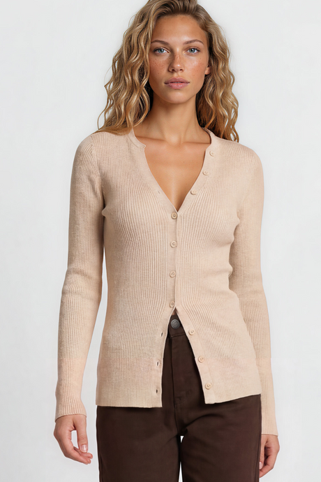 Woman wearing a beige cardigan and brown pants on a plain background
